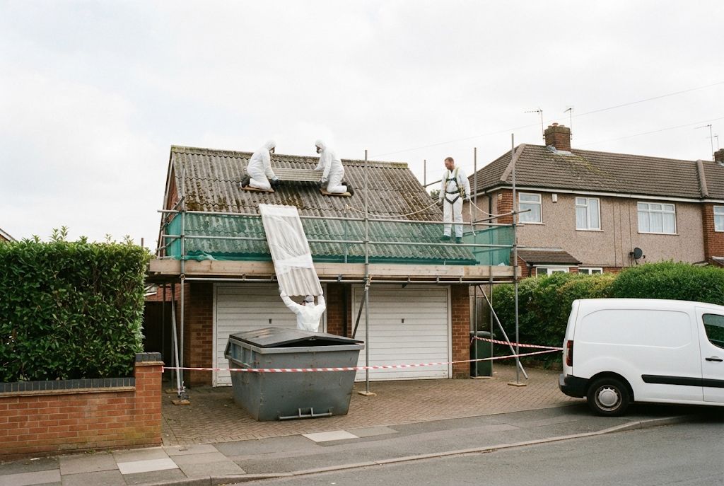 Trained operatives removing an old asbestos cement garage roof from a scaffold